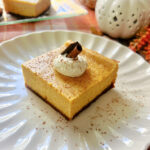 A pumpkin cheesecake bar on a white dessert plate.