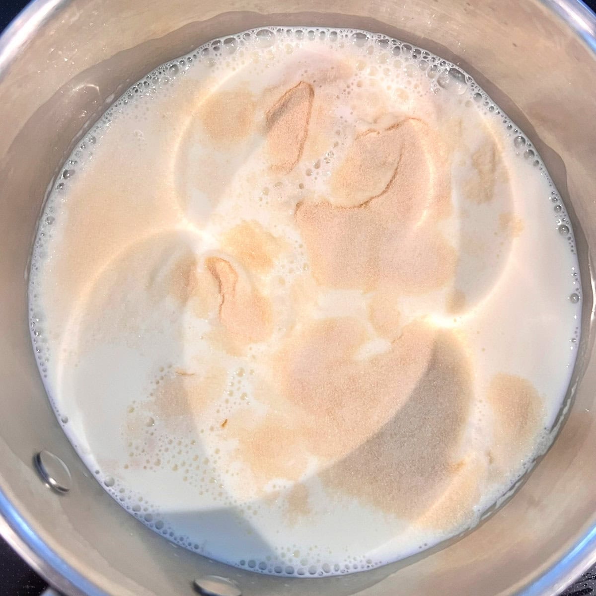 Blooming gelatin in milk in a saucepan for vanilla bean panna cotta.