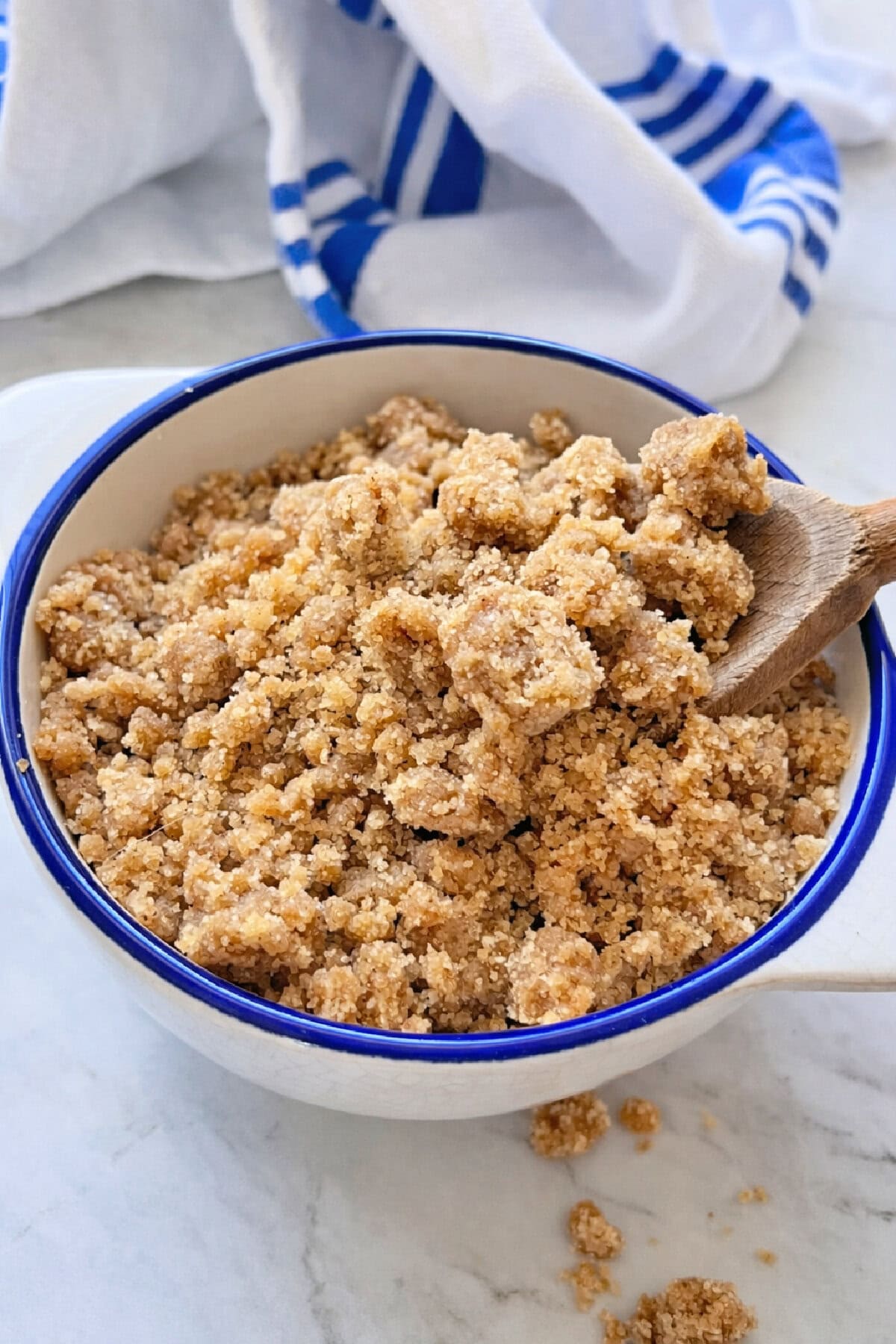 Bakery Style Cinnamon Streusel in a bowl with a wooden spoon.