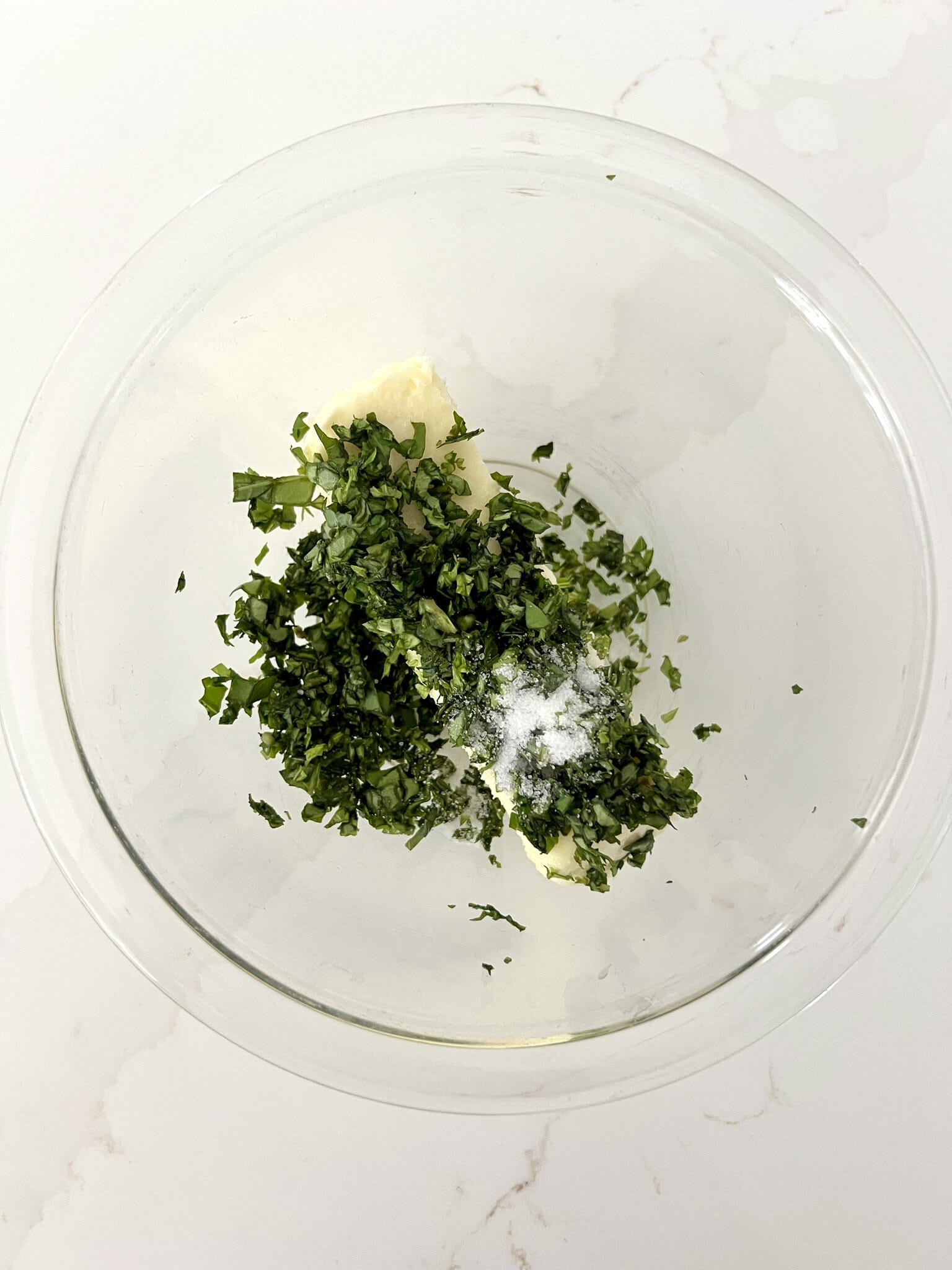 Chopped basil, softened butter and sea salt in a bowl.