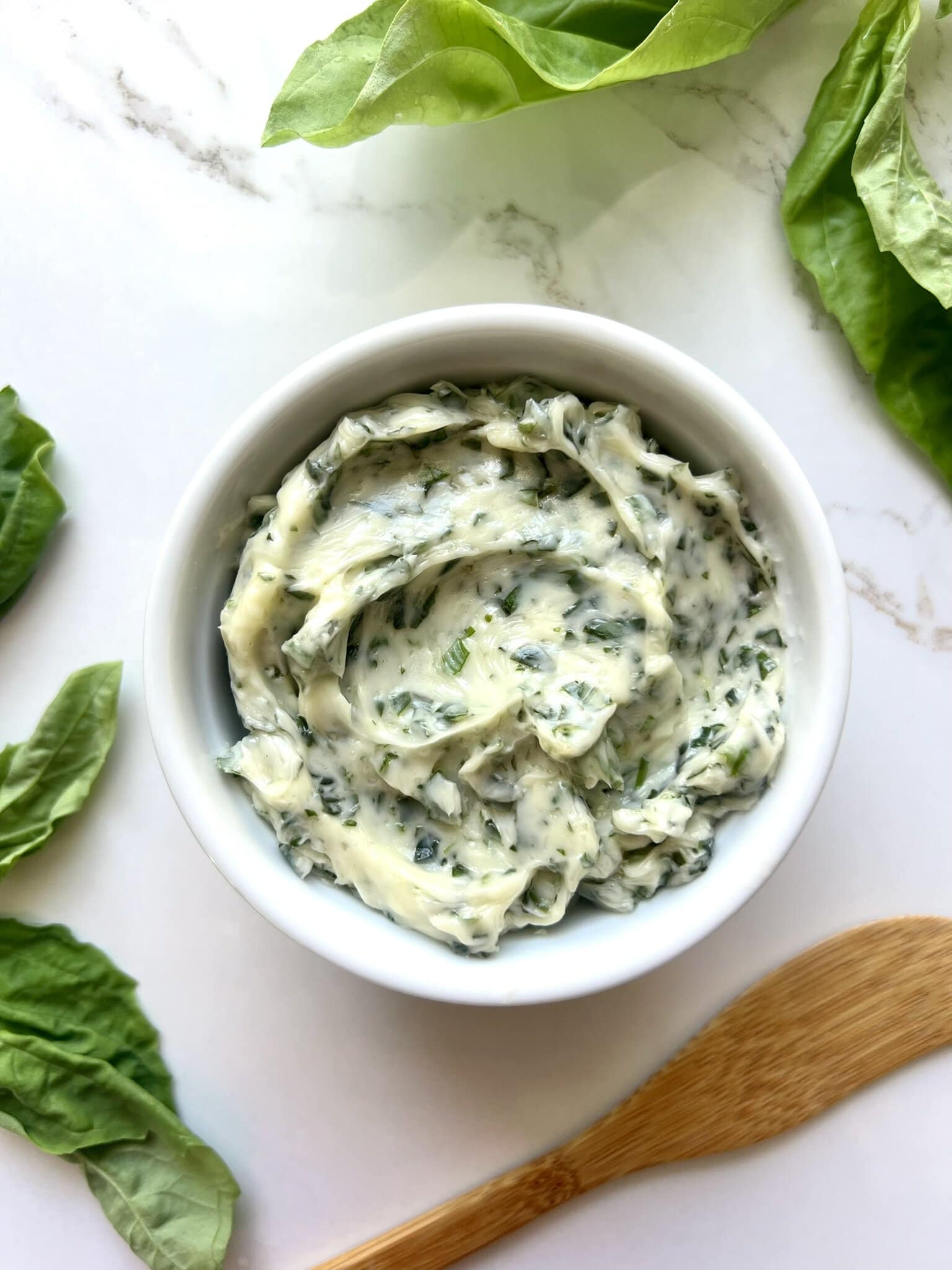 A small white ramekin filled with Basil Butter.